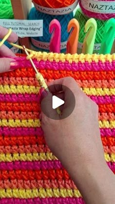 a person is knitting yarn on a crocheted surface with scissors and markers in front of them