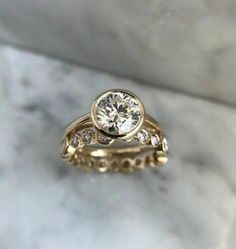 a close up of a diamond ring on a marble surface