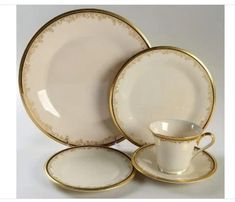 a white and gold dinner set with saucers