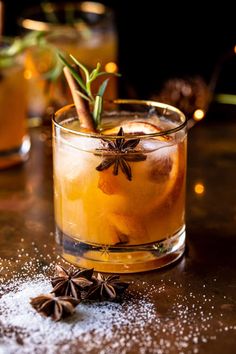 an old fashioned cocktail is garnished with cinnamon, star anise and spices