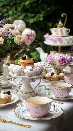 a table topped with cups and plates filled with cupcakes