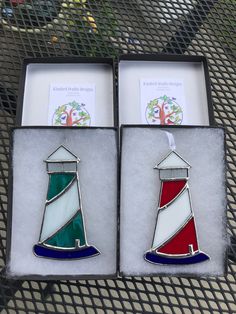 two christmas ornament shaped like lighthouses sitting in a box on a table