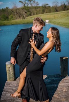 a man and woman are standing on a dock