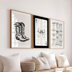 three framed pictures hang on the wall above a white couch with pillows and throw pillows