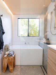 a bathroom with a bathtub, sink and mirror