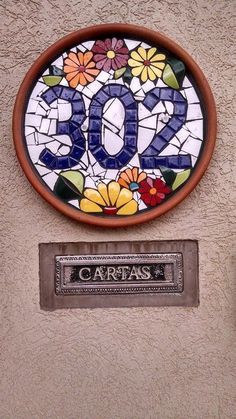 a sign on the side of a building with flowers painted on it's front