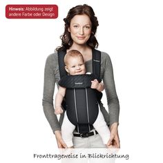 a woman holding a baby in a black carrier