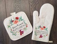 two oven mitts with embroidered flowers on them, one has a name and the other has a floral design