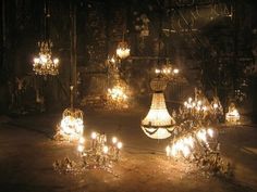 a bunch of chandeliers that are lit up in some kind of dark room