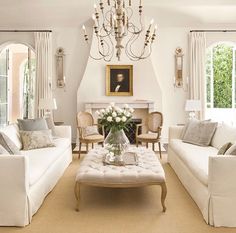 a living room filled with furniture and a chandelier