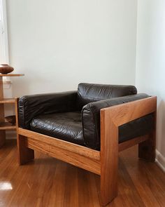 a black leather chair sitting on top of a hard wood floor