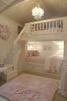 a white bunk bed sitting under a chandelier