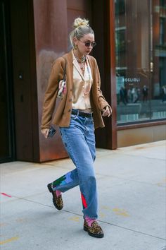 a woman walking down the street with her foot in the air