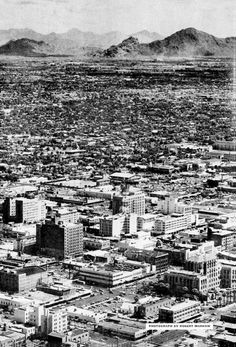 black and white photograph of cityscape with mountains in the background