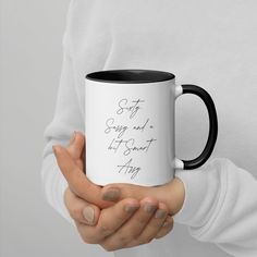 a woman holding a black and white coffee mug with the words stay strong and let go