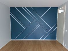 an empty room with wood flooring and blue wall art on the wall behind it