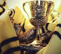 a golden trophy sitting on top of a pile of sweaters next to a soccer ball