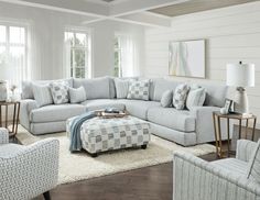 a living room filled with lots of furniture and pillows on top of a white rug