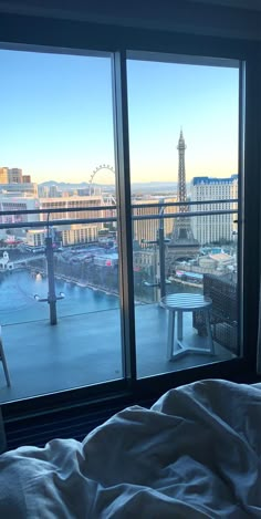 a bedroom with a view of the eiffel tower from it's window