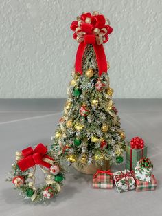 a small christmas tree with presents around it