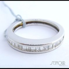 a white gold ring with baguets set in the middle, on a string