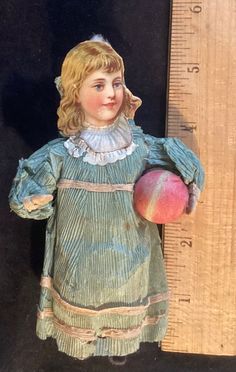 an old doll is next to a ruler