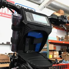 the back end of a motorcycle in a garage with boxes and other items on shelves