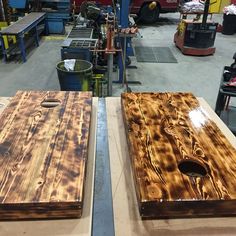 two pieces of wood sitting on top of a table in a room filled with machines