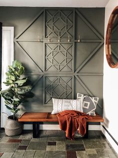 a wooden bench sitting under a mirror next to a potted plant