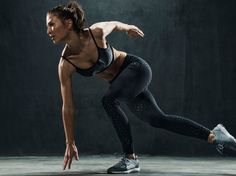 a woman in black sports bra top and leggings doing push ups with one hand