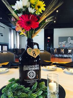 a table with a bottle and flowers on it