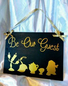 a wooden sign that says be our guest with silhouettes of disney characters on it