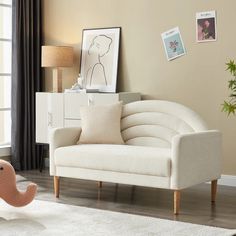 a living room with a couch, chair and pictures on the wall