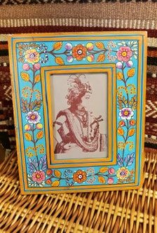 an old photo frame sitting on top of a wicker chair