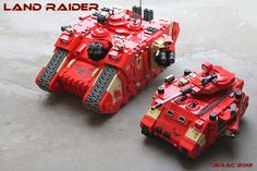 two red and yellow toy tanks sitting on top of a cement floor next to each other