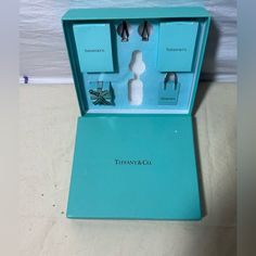 an opened tiffany & co gift set in a blue box on a white floor next to a wall