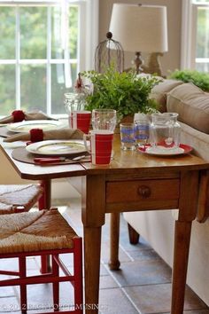 a living room filled with furniture and a wooden table topped with glasses next to a couch