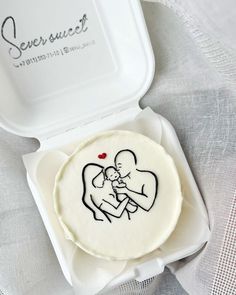 a small cake in a white box with a drawing on it's front and side