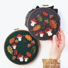 two hand embroidered hoop purses sitting next to each other