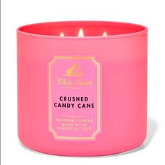 a pink candle that is sitting in front of a white background with the words crushed candy cane on it