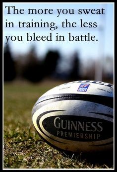 a rugby ball sitting in the grass with a quote on it