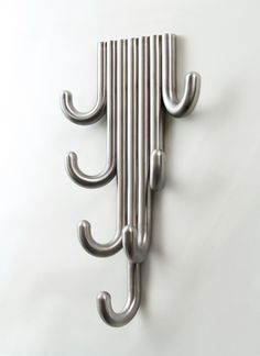 a metal coat rack with three hooks on it