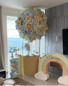 a balloon filled with lots of balloons sitting on top of a table next to a tv