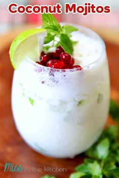 a small glass filled with fruit and garnish on top of a wooden cutting board