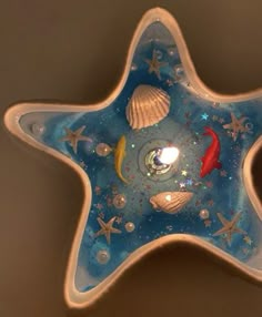 a blue glass star with shells and stars on it