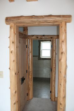 an open door leading to another room in a house with white walls and wood trim