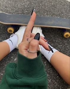 a person with their fingers in the shape of a peace sign and holding a skateboard