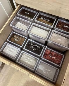 an open drawer filled with lots of different types of spices on top of a wooden table