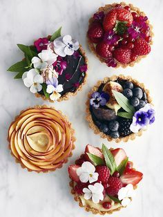 three small pies with flowers and berries on them, one has the words bakes d'oeuvres