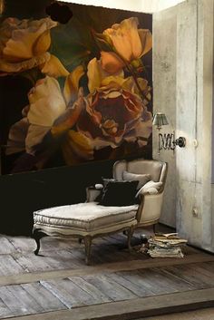 a chair and ottoman in front of a wall with flowers painted on the wall behind it